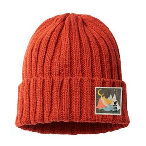 May include: Rust-colored knit beanie with a folded brim. A square patch on the front features a mountain scene with a crescent moon, stars, and trees. The beanie is made of a ribbed knit material.