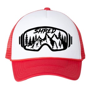 Puede incluir: Una gorra de camionero blanca y roja con un gráfico negro de unas gafas de esquí con montañas y árboles en su interior. El texto "SHRED" está impreso sobre las gafas.