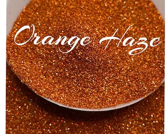 May include: A close-up of a small bowl filled with orange glitter, labeled "Orange Haze".