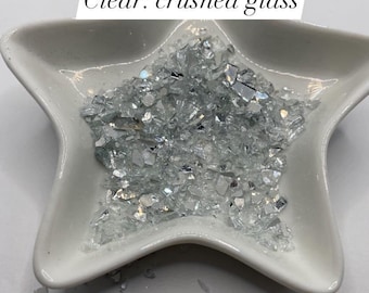 May include: A white ceramic star-shaped dish filled with clear crushed glass. The dish is on a white surface. $2 - 1oz Clear: crushed glass