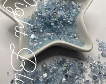 May include: Light blue crushed glass, a 1 oz bag for $2. The glass is iridescent and has a mix of small and large pieces.