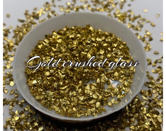 May include: A white bowl filled with gold crushed glass. The glass is in various sizes and shapes.