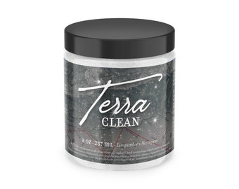 May include: A white jar with a black lid and a label that says "Terra CLEAN 8 OZ-237 ML Limpiador Nettoyeur". The label has a stylized map with stars and the word "Terra" written in cursive.