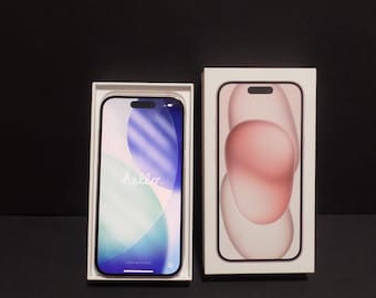 May include: A smartphone with a dark frame and a screen displaying the word hello in white text, positioned next to its white rectangular packaging box which features a graphic of the phone on the front cover with a pink and white abstract design.