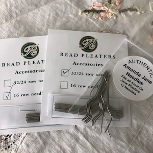 May include: Two packages of Read Pleaters Accessories needles. One package is checked for 16 row needles. A clear plastic bag contains a bundle of silver-colored needles. A round sticker reads "AUTHENTIC Amanda Jane Needles."