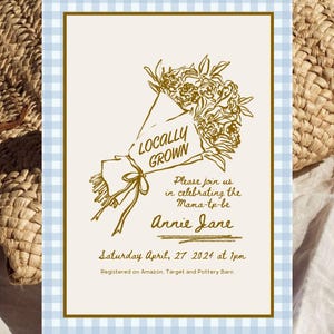 May include: An invitation with a light blue and white gingham border. The invitation features a gold illustration of a bouquet of flowers with the words "Locally Grown". Text on the invitation reads "Please join us in celebrating the Mama-to-be Annie Jane".