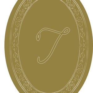 May include: An oval-shaped design in a muted gold color, featuring a white floral border and a stylized letter "T" in the center. The design has a vintage or antique aesthetic, suitable for various decorative applications.