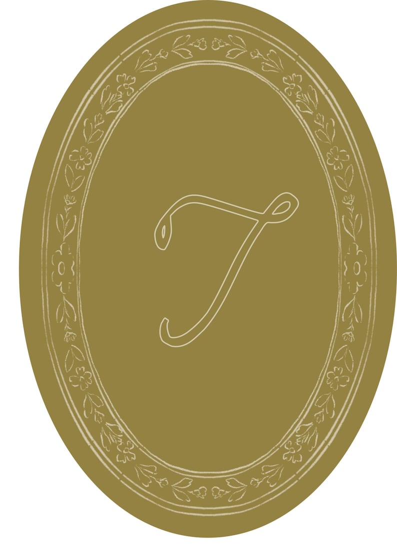May include: An oval-shaped design in a muted gold color, featuring a white floral border and a stylized letter "T" in the center. The design has a vintage or antique aesthetic, suitable for various decorative applications.