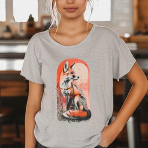 May include: A light gray t-shirt with a graphic of a fox sitting in front of a sunset. The fox is orange and white with a black nose and eyes.