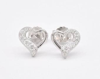 May include: A pair of silver heart-shaped earrings with a row of small clear stones around the edge of each heart.