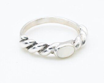 May include: A silver ring with a twisted band and a white oval-shaped gemstone.