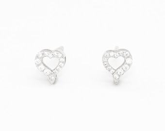 May include: A pair of silver heart-shaped earrings with small clear cubic zirconia stones.