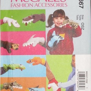 May include: McCall's Fashion Accessories pattern featuring various animal-themed hand puppets. The puppets include a bear, shark, and leopard print designs. The pattern also shows a child wearing a leopard print puppet.