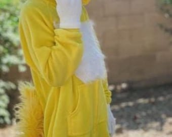 May include: A yellow jumpsuit costume with a hood featuring large, fluffy yellow ears and a matching tail. The costume includes white gloves and a white chest patch. The person is wearing red and white shoes.