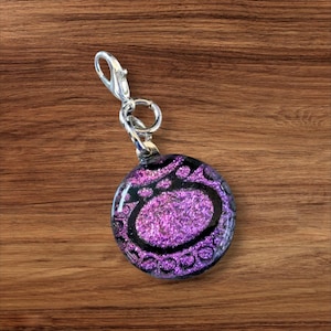 Zipper Pull/Zipper Charm:  Hot pink circular charm with a black oval design---Item Z193