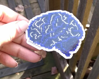 May include: A blue and white brain-shaped sticker with the text "Dr. Frankenstein" on the bottom.