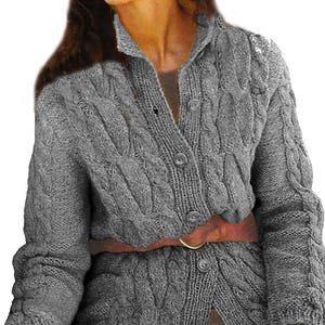 Könnte beinhalten: Graue Strickjacke mit Zopfmuster, Knopfleiste und langen Ärmeln. Der Pullover wird mit einem braunen Gürtel in der Taille zusammengehalten. Die Strickjacke hat einen Kragen und ein strukturiertes Design.