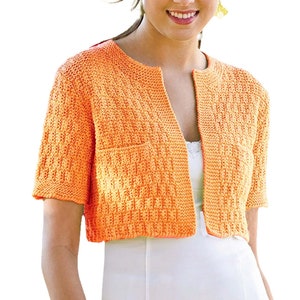 Könnte beinhalten: Ein orangefarbener Cardigan mit kurzen Ärmeln und einem strukturierten Strickmuster. Das offene Design hat zwei kleine Taschen und einen runden Ausschnitt. Der Cardigan besteht aus einem weichen, leichten Material und ist etwa 40 cm lang.