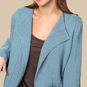 Peut inclure: Un cardigan en tricot bleu clair avec un col châle. Le cardigan est ouvert à l'avant et a une texture côtelée.
