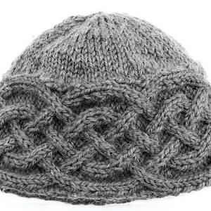 May include: A gray knitted beanie hat with a cable knit design around the brim. The hat is made of a soft, textured yarn and is suitable for cold weather. The hat is a neutral color and can be worn by anyone.