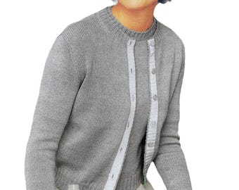 May include: A light grey knit sweater set, comprising a crew neck sweater and a button-up cardigan with white trim. The person is wearing a light grey skirt and holding a water bottle. The overall style is classic and simple.