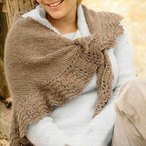 May include: A brown knitted shawl with a delicate lace pattern. The shawl is draped over a person's shoulders and tied at the neck.