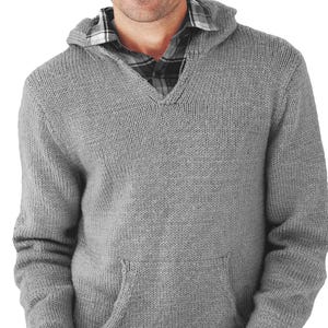 May include: A gray knit hoodie with a front pocket and a V-neck. The hoodie has a drawstring hood and ribbed cuffs and hem. A plaid shirt is visible underneath the hoodie.