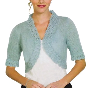 May include: A light blue knitted bolero with short sleeves. The bolero features a scalloped edge along the collar and sleeve cuffs. The open front design is visible against a white top.
