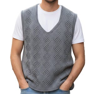Può includere: Un gilet grigio lavorato a maglia con scollo a V. Il gilet presenta un motivo strutturato ed è indossato sopra una maglietta bianca. La persona indossa jeans blu e ha le mani in tasca. Il gilet è di colore grigio medio.