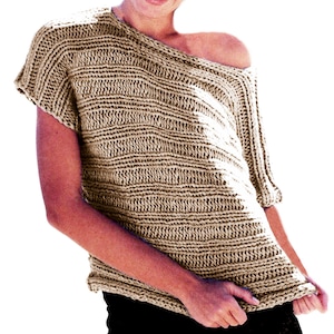 May include: A beige, off-the-shoulder knit top with short sleeves. The top features a textured, horizontal ribbed pattern. The person is wearing black trousers. The top is made of a soft, comfortable material.