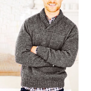 May include: A gray knitted sweater with a wide, folded collar. The sweater has a textured, slightly speckled appearance.