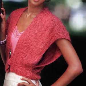 May include: A pink knitted shrug with a V-neck and short sleeves.
