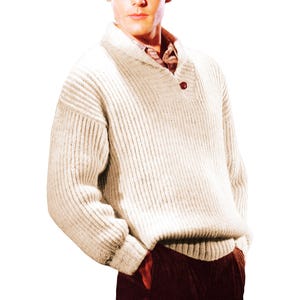 Puede incluir: Suéter de punto acanalado color crema con cuello chal y cierre de un solo botón marrón. El suéter tiene mangas largas y un ajuste relajado. La persona lleva una camisa estampada debajo. El suéter es de estilo clásico.