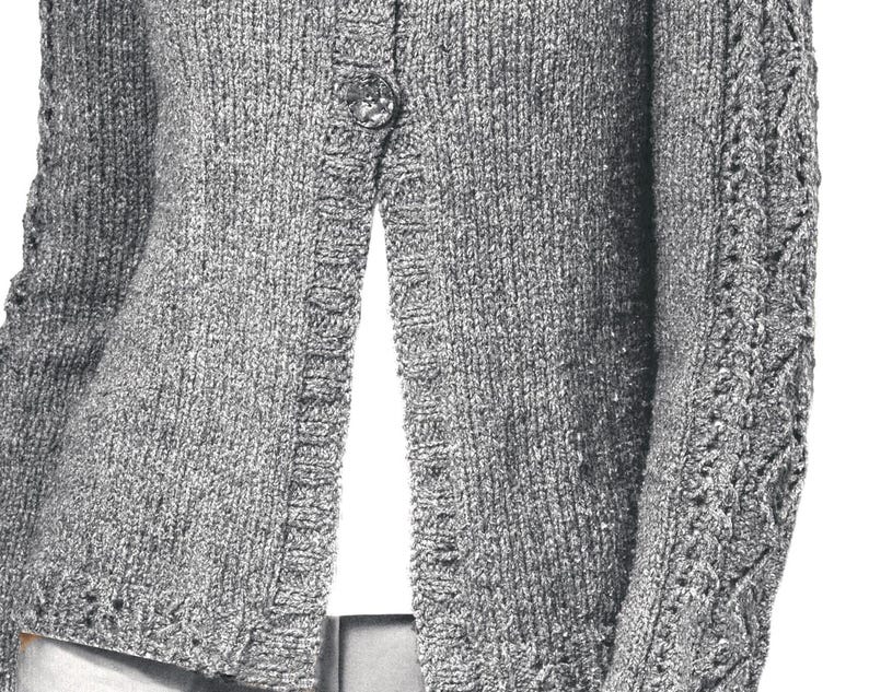 May include: A gray knitted cardigan with a button closure and a cable knit pattern on the sleeves.
