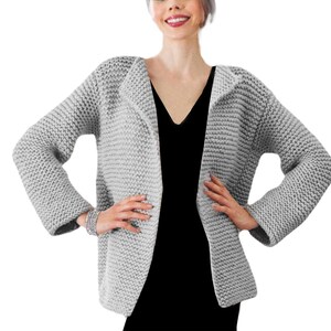 May include: A gray knitted cardigan with a shawl collar and long sleeves. The cardigan is open in the front and has a relaxed fit.