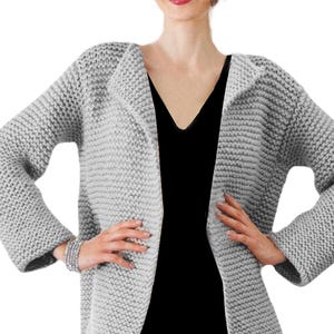 May include: A gray knitted cardigan with a long, open front and long sleeves. The cardigan is made of a soft, chunky yarn.