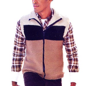 May include: A knitted vest with a color-block design. The vest features a beige, black, and tan color scheme with a full zipper. The person is wearing a plaid shirt underneath. The vest has a collared neckline and ribbed cuffs.