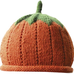 May include: An orange knitted hat in the shape of a pumpkin, featuring green leaves and a stem. The hat is made from textured yarn and has a ribbed brim. A playful accessory for autumn or Halloween.