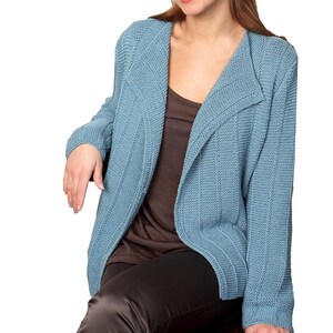 May include: A light blue knitted cardigan with a shawl collar and long sleeves. The cardigan is open in the front and has a ribbed texture.