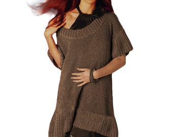 May include: A brown knitted sweater with short sleeves and a flared hem. The sweater features a wide, rounded neckline and is worn over a dark top. A matching bracelet is visible on the wrist. The style suggests a casual, yet stylish garment.