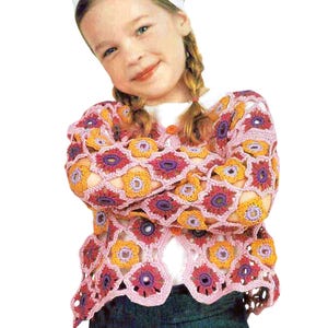 Könnte beinhalten: Eine rosa gehäkelte Strickjacke mit einem Blumenmuster in den Farben Lila, Orange und Rosa. Die Strickjacke hat einen Knopfverschluss und lange Ärmel.