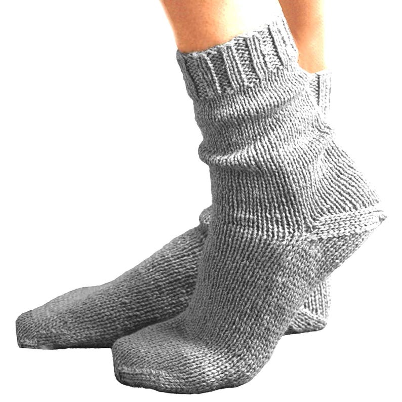 Puede incluir: Un par de calcetines de punto grises. Los calcetines est&aacute;n hechos de un hilo grueso y texturizado y tienen un pu&ntilde;o acanalado. Los calcetines est&aacute;n dise&ntilde;ados para ser usados en los pies y los tobillos.