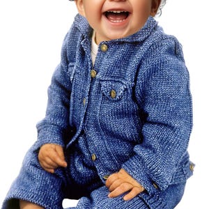 May include: A smiling baby wearing a blue knitted outfit. The outfit includes a jacket with gold buttons and a matching pair of pants. The knitted texture is visible, and the overall style is casual and comfortable.