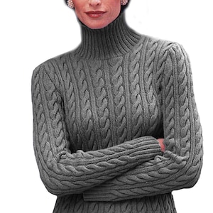 Op de afbeelding: Een grijze kabel gebreide trui met een close-up van het breipatroon.