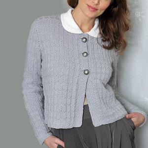 May include: A gray knitted cardigan with a white collar and silver buttons. The cardigan has a slightly cropped length and long sleeves.