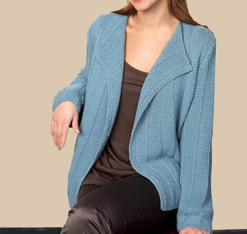 May include: A light blue knitted cardigan with a shawl collar. The cardigan is open in the front and has a ribbed texture.