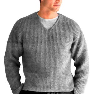 May include: A gray, ribbed-knit sweater with a V-neck. The sweater is a medium gray color and appears to be made of a thick, warm material. The sweater is worn over a light gray undershirt.