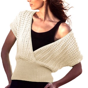 May include: A cream-coloured knitted top with a V-neck and short sleeves. The top has a loose, flowing fit and a delicate openwork pattern.