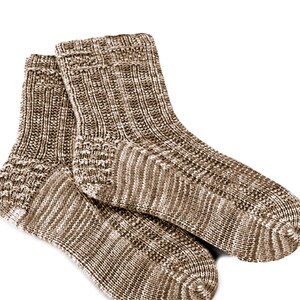 May include: A pair of brown and white knitted socks with a textured pattern.