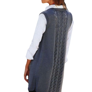 May include: A long, gray knitted vest with a delicate lace pattern on the back. The vest has a V-neck and a relaxed fit.